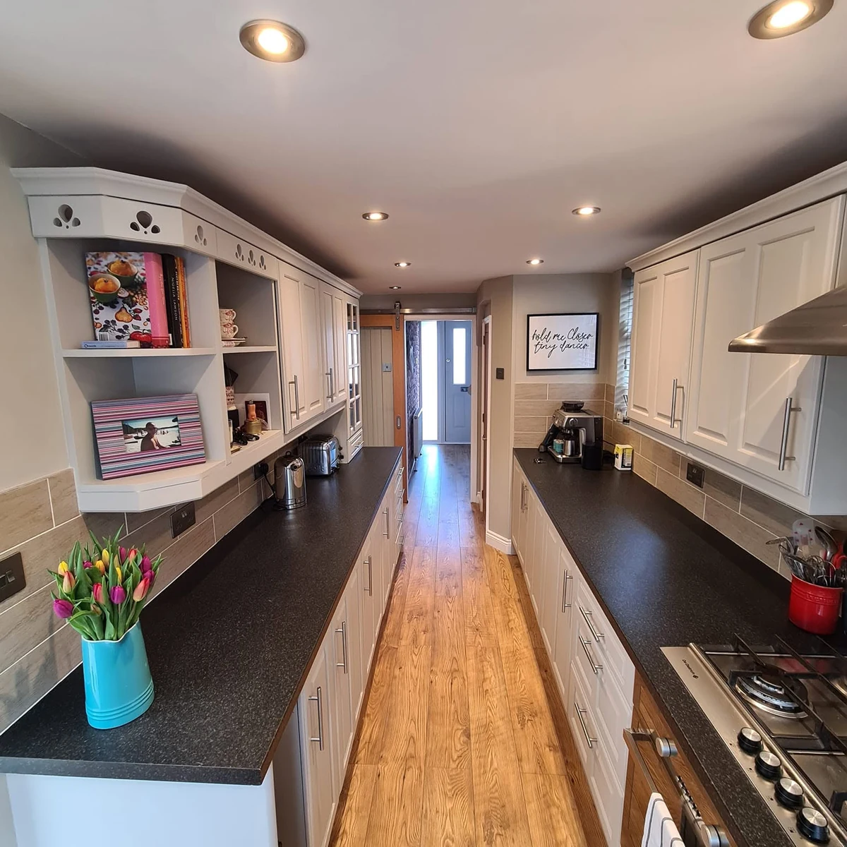 Bright galley kitchen with freshly painted shaker units and dark worktops